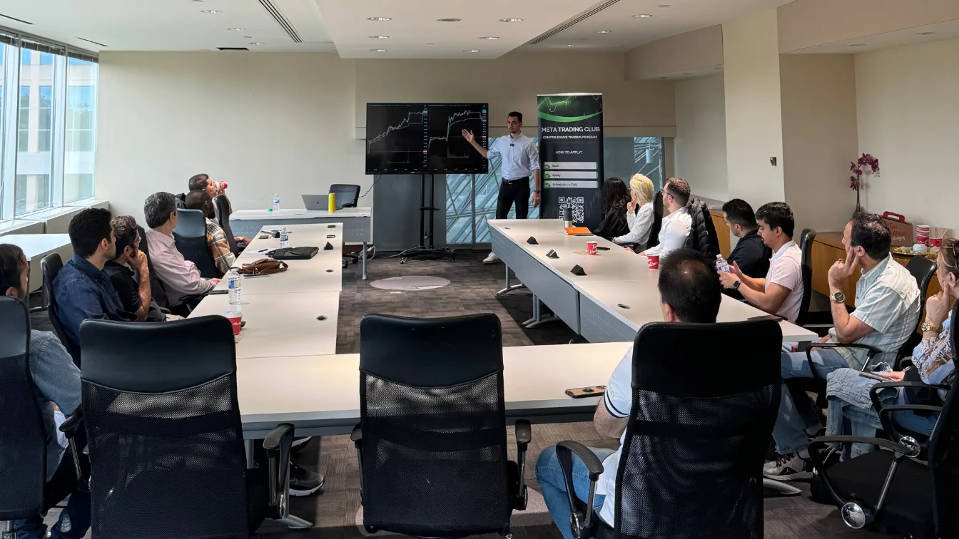 Attendees seated along a boardroom table during a Meta Trading Club session