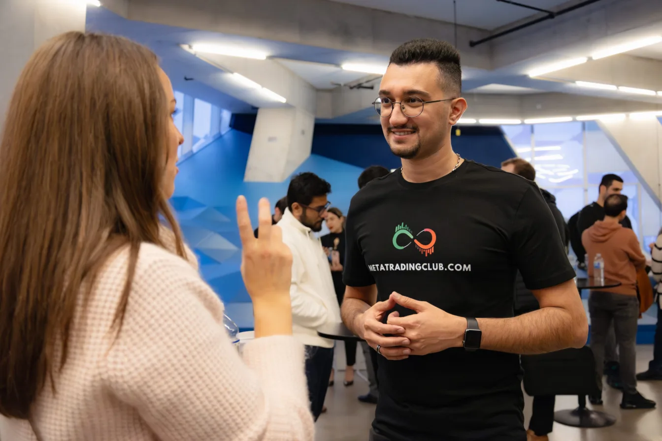 Two Meta Trading Club members talking at a community meetup