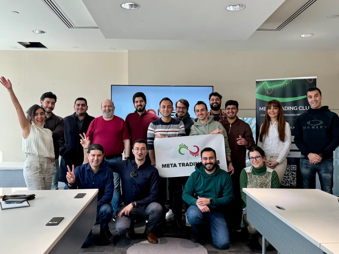 Meta Trading Club members posing with the club banner after a trading workshop